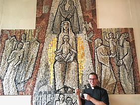Das Mosaik in Kreuzesform in der Pfarrkirche Maria am Hauch in Röthenbach zeigt den freudenreichen Rosenkranz. „Somit wird deutlich, dass der Gekreuzigte im Zentrum des Rosenkranzgebets steht“, sagt Kaplan Simon Heindl.