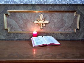 Kerze und Buch for einem Altar.